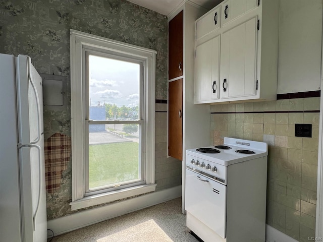 kitchen with white appliances, white cabinetry, and a healthy amount of sunlight