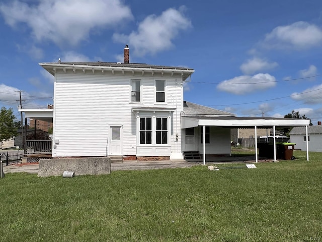 rear view of property featuring a yard and a carport