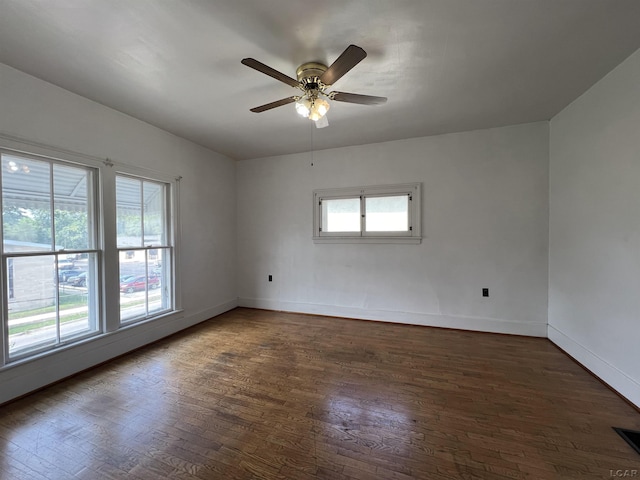 empty room featuring dark hardwood / wood-style floors, plenty of natural light, and ceiling fan