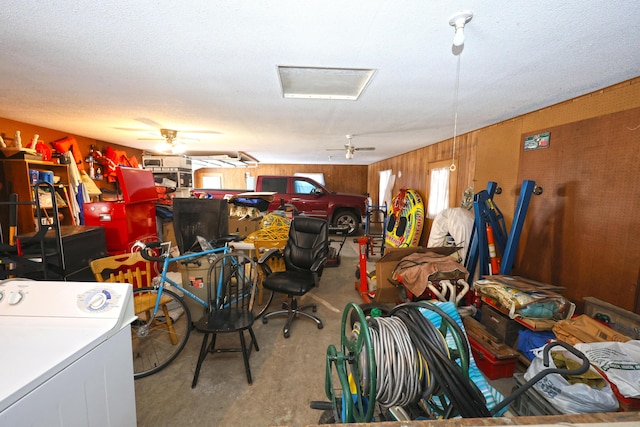 garage with ceiling fan, wooden walls, and washer / clothes dryer