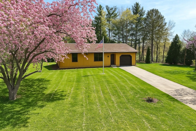 ranch-style home with a garage, a front lawn, and concrete driveway