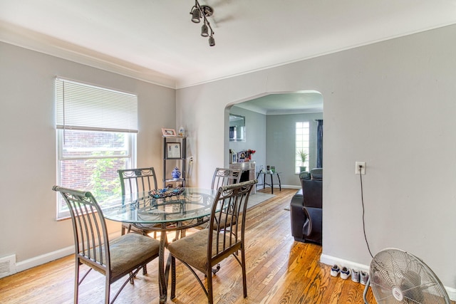 dining space with light hardwood / wood-style floors and crown molding