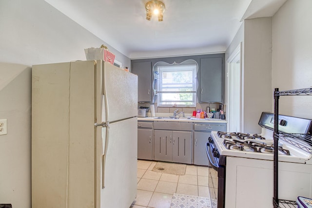 kitchen with sink, white appliances, gray cabinets, and light tile patterned flooring