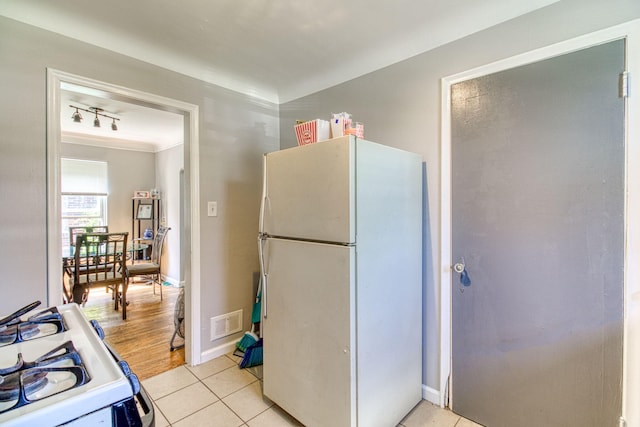 kitchen with light tile patterned floors, white appliances, and ornamental molding