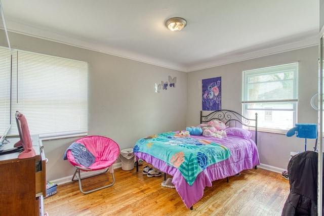 bedroom featuring wood-type flooring and ornamental molding