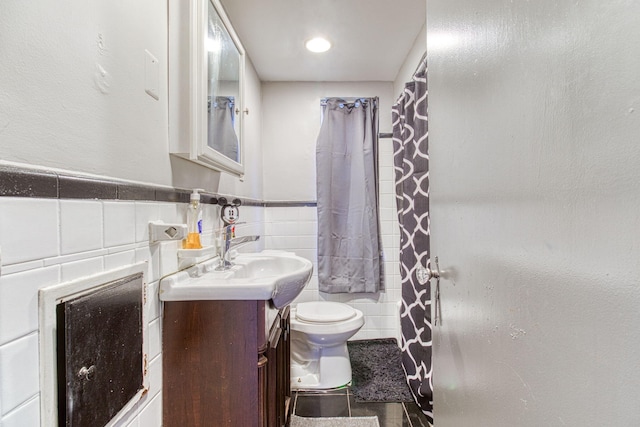 bathroom with tile patterned flooring, vanity, toilet, and tile walls