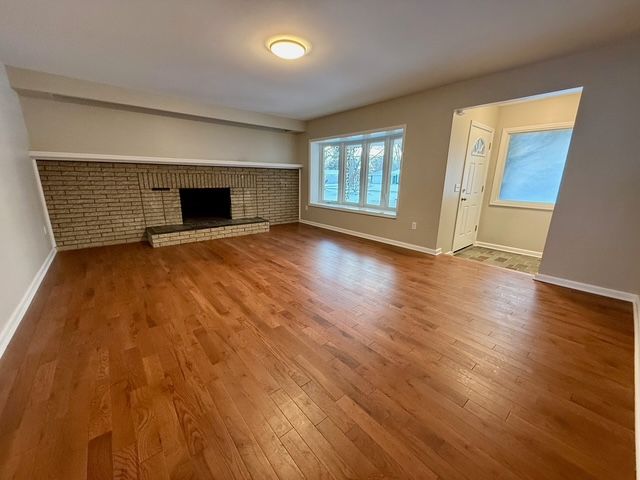 unfurnished living room featuring hardwood / wood-style floors and a fireplace