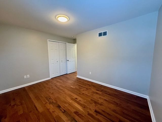 unfurnished bedroom with hardwood / wood-style floors and a closet