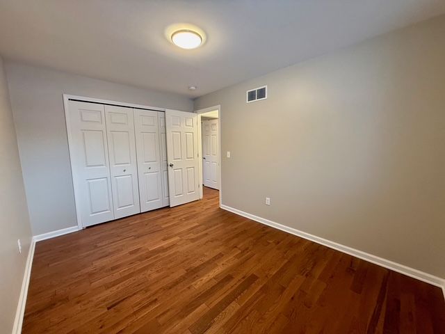 unfurnished bedroom with hardwood / wood-style floors and a closet