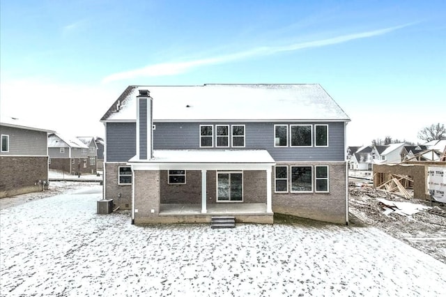 snow covered property with central air condition unit