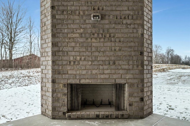 exterior details featuring an outdoor brick fireplace