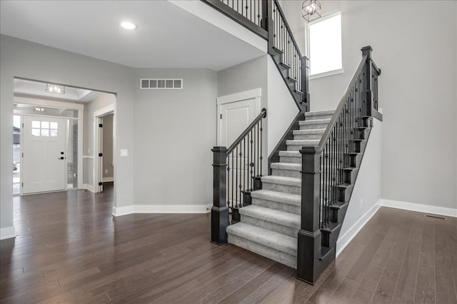 stairway with hardwood / wood-style floors and plenty of natural light