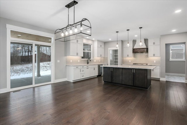 kitchen with a center island, decorative light fixtures, white cabinetry, and stainless steel dishwasher