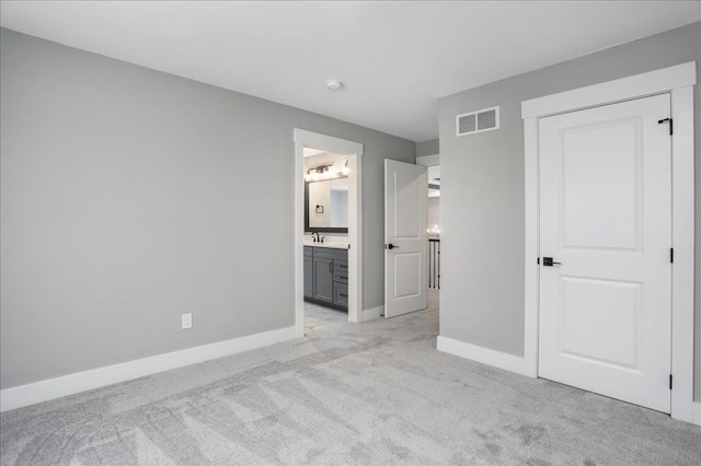 unfurnished bedroom featuring light colored carpet, sink, and connected bathroom