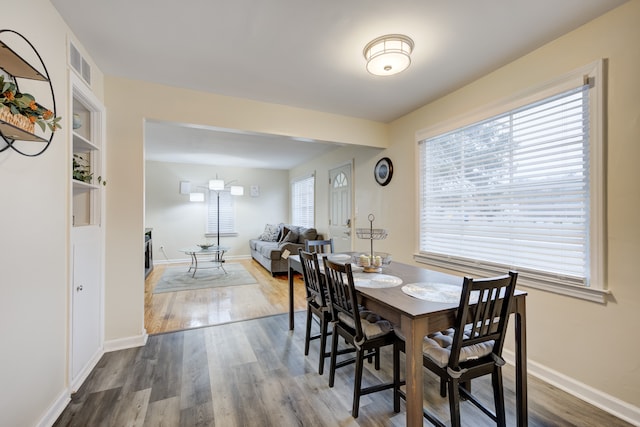 dining room featuring hardwood / wood-style flooring and built in shelves