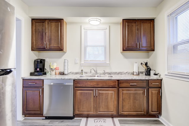 kitchen with sink, stainless steel appliances, and light hardwood / wood-style floors