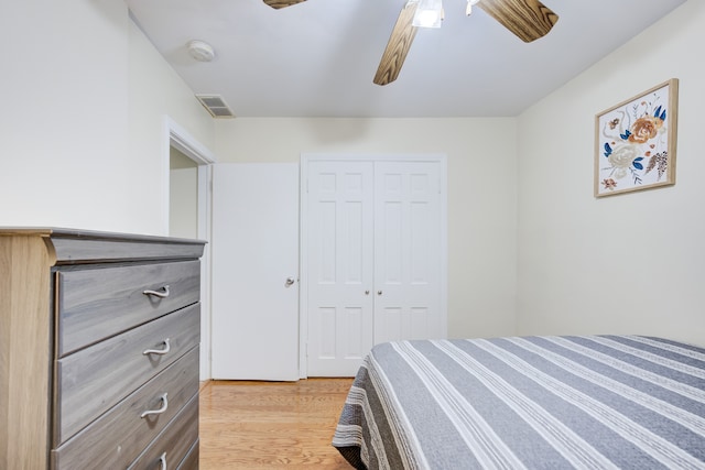 bedroom with ceiling fan, light hardwood / wood-style flooring, and a closet