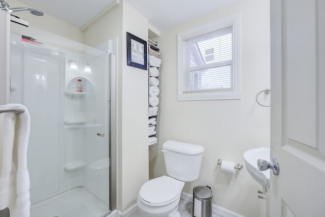 bathroom with toilet and a shower with door