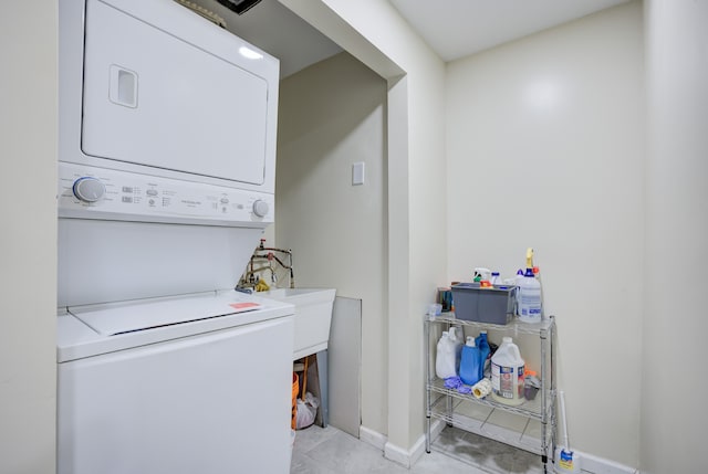 clothes washing area with light tile patterned floors and stacked washer / drying machine