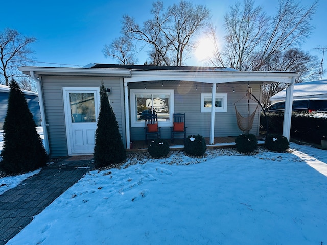 view of snow covered back of property