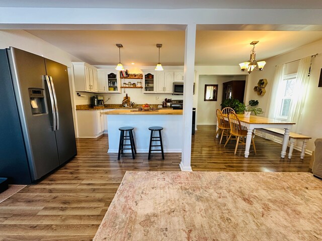 kitchen with white cabinetry, stainless steel appliances, dark hardwood / wood-style floors, a notable chandelier, and butcher block countertops