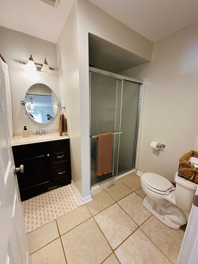 bathroom featuring tile patterned flooring, vanity, toilet, and walk in shower