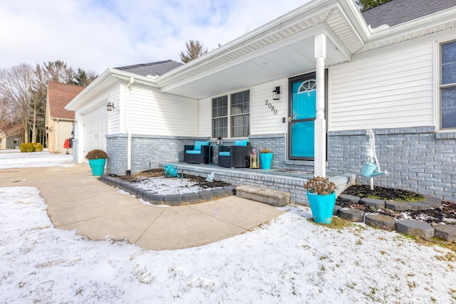 entrance to property featuring a porch and a garage