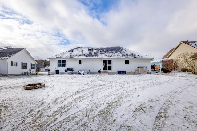 snow covered property featuring an outdoor fire pit