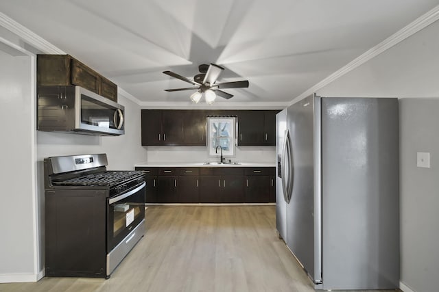 kitchen featuring stainless steel appliances, light hardwood / wood-style floors, ornamental molding, and sink