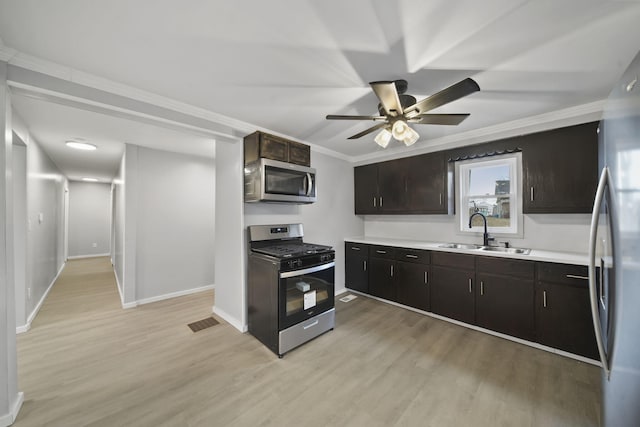 kitchen with sink, stainless steel appliances, ornamental molding, dark brown cabinets, and light wood-type flooring