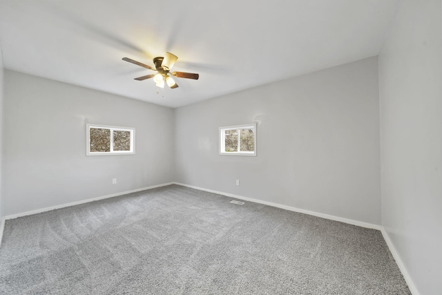 carpeted spare room with ceiling fan