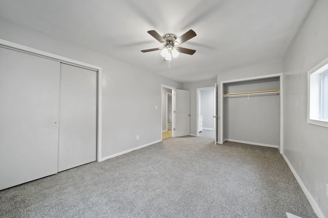 unfurnished bedroom with carpet, two closets, and ceiling fan