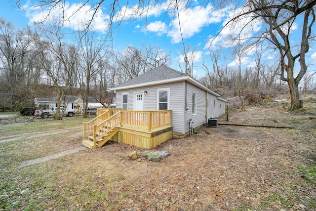 view of side of property with a wooden deck and central AC