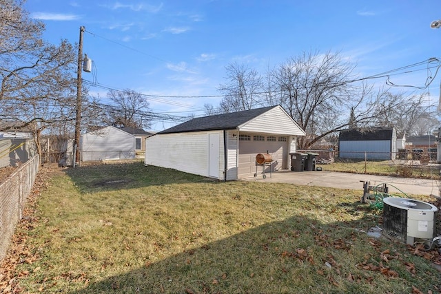 view of yard with an outbuilding, central AC unit, and a garage