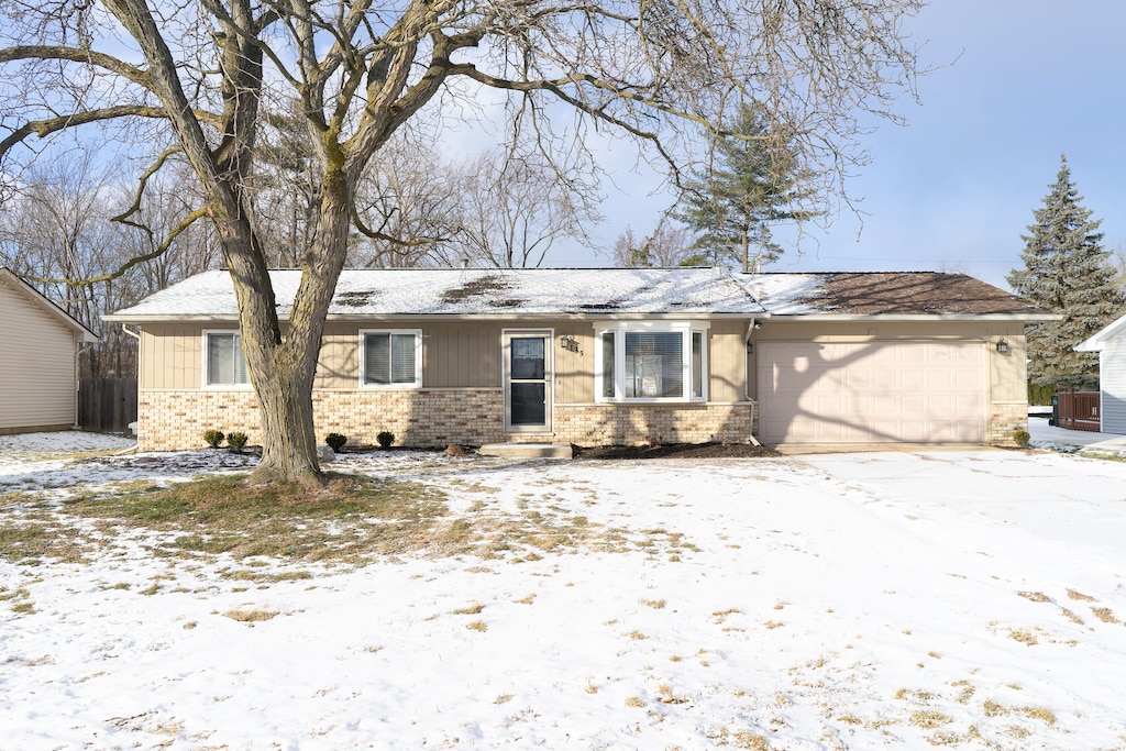 ranch-style house with a garage and cooling unit