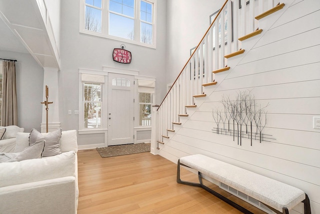 foyer with hardwood / wood-style flooring and a towering ceiling