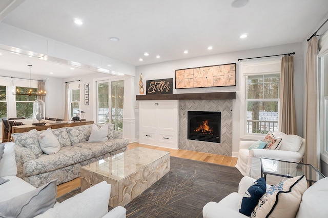 living room with an inviting chandelier, hardwood / wood-style flooring, and a fireplace