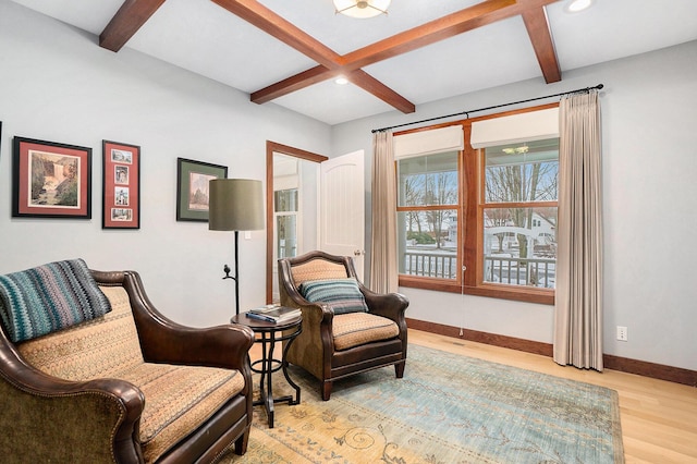 living area with coffered ceiling, beam ceiling, and light hardwood / wood-style floors