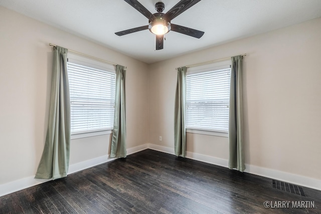 unfurnished room featuring ceiling fan, a wealth of natural light, and dark hardwood / wood-style floors