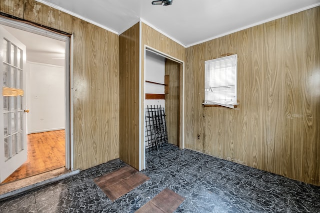 bedroom featuring a closet, crown molding, and wood walls