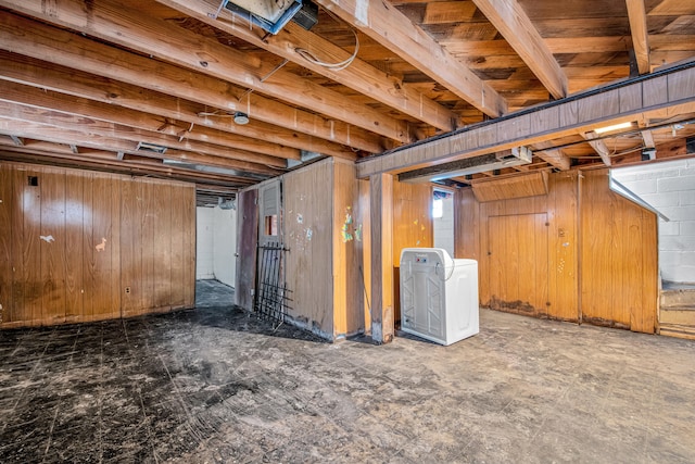 basement with washer / clothes dryer and wooden walls