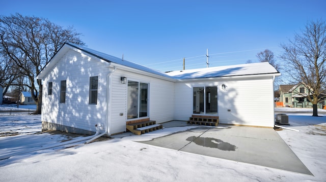 view of snow covered back of property