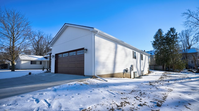 snow covered property with a garage