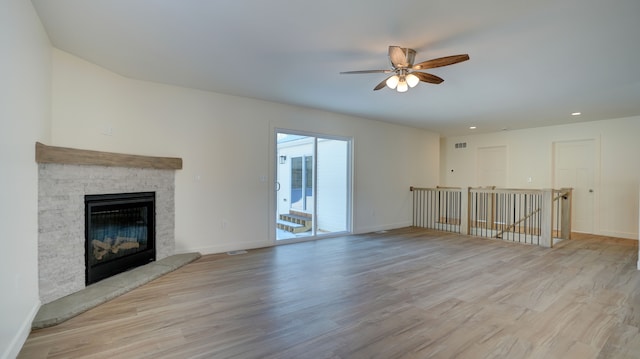 unfurnished living room with ceiling fan, light hardwood / wood-style floors, and a fireplace