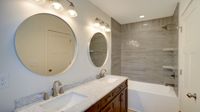 bathroom featuring vanity and tiled shower / bath