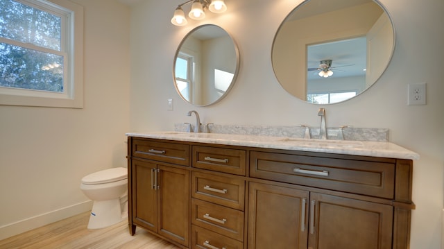 bathroom with vanity, hardwood / wood-style flooring, toilet, and ceiling fan