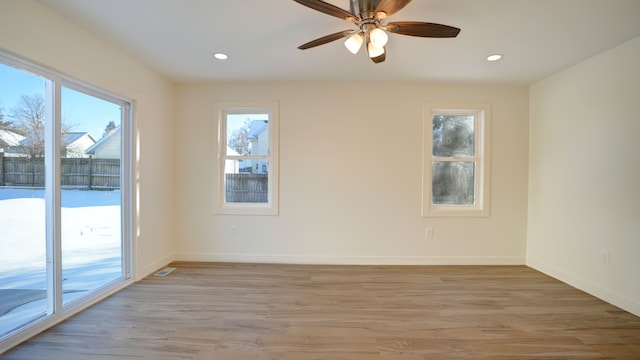 spare room featuring plenty of natural light, light hardwood / wood-style floors, and ceiling fan