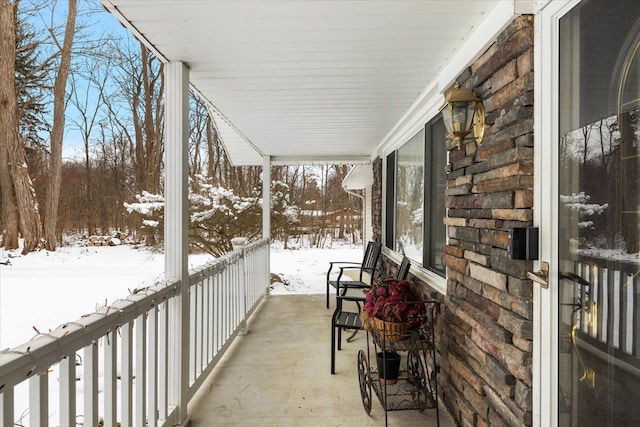 view of snow covered back of property