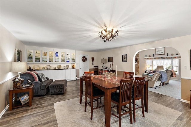 dining space featuring wood-type flooring and a chandelier