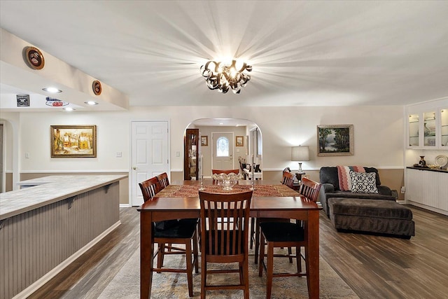 dining area with dark hardwood / wood-style flooring and a notable chandelier